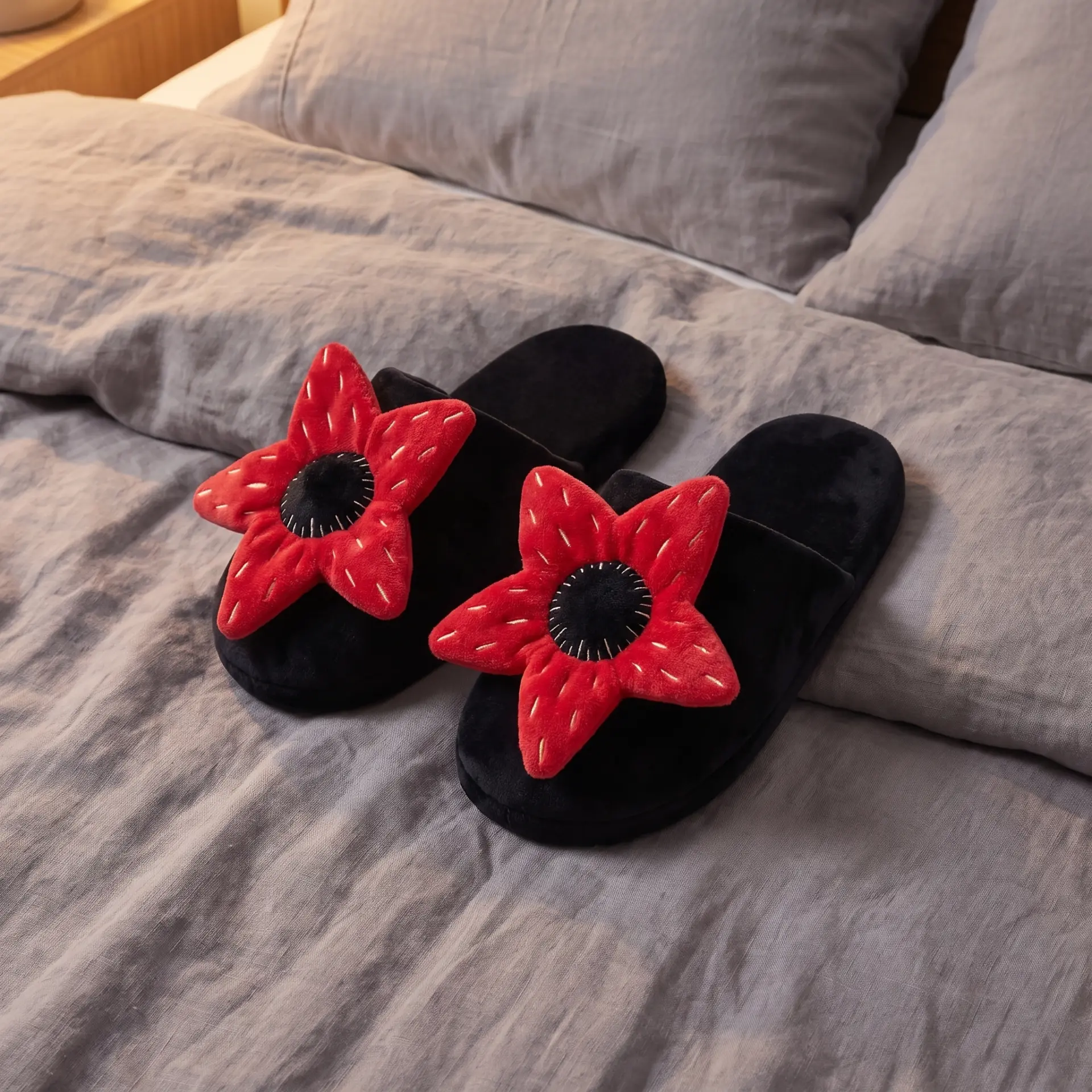 Black plush slippers topped with red five-petal monster blooms